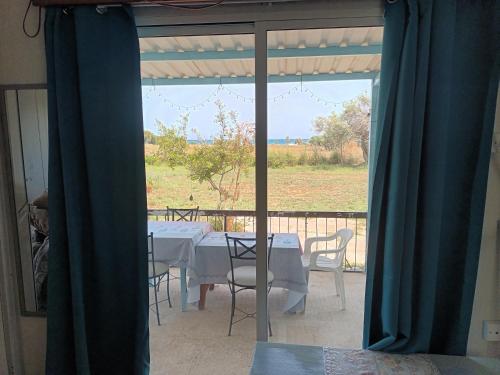 a dining room with a table and chairs on a balcony at Mazotos beach house in Mazotos