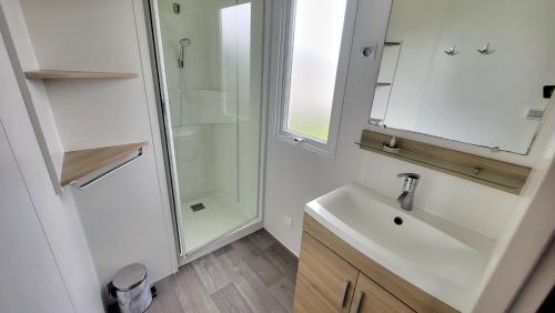 une salle de bain blanche avec un lavabo et une douche dans l'établissement Ti Punch - Sables-dOlonne Nord - Camping La Plage, à Saint-Hilaire-de-Riez