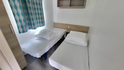 une petite pièce avec un lit et une fenêtre dans l'établissement Ti Punch - Sables-dOlonne Nord - Camping La Plage, à Saint-Hilaire-de-Riez