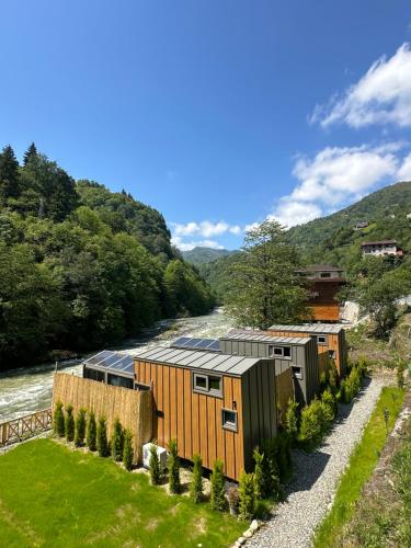 a house with a river in the background at Ria süit otel bungalov in Rize