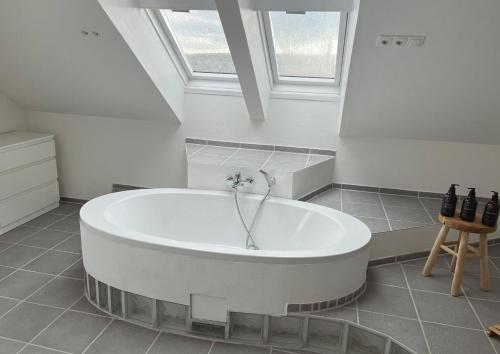 a white bath tub in a bathroom with a window at 110 qm Stadtnahe Oase im Grünen in Priesendorf