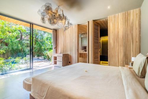 um quarto com uma cama grande e uma janela grande em Hygge Villa Ubud em Ubud