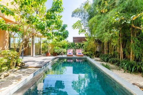 uma piscina com duas cadeiras num quintal em Hygge Villa Ubud em Ubud