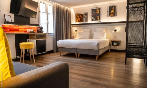 パリにある26 Faubourg - Ex-Hotel de Reimsのベッドと椅子付きのホテルルーム