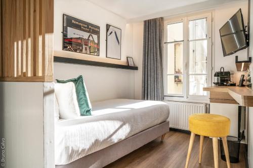パリにある26 Faubourg - Ex-Hotel de Reimsのベッドと窓が備わるホテルルーム