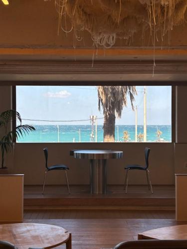 a table and chairs in a room with a view of the ocean at Gongzone Stay in Jeju