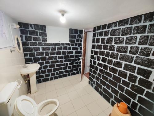 Łazienka z murem z czarno-białej cegły w obiekcie Green acres w mieście Masinagudi