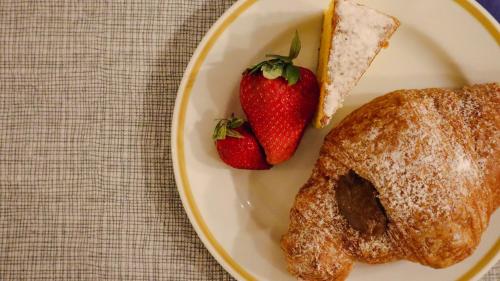a plate with a pastry and strawberries on a table at Hotel Enzo in Porto Recanati