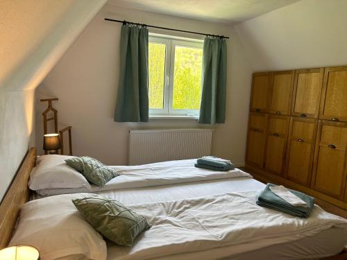 2 camas individuales en un dormitorio con ventana en Flow House, en Satu Mare