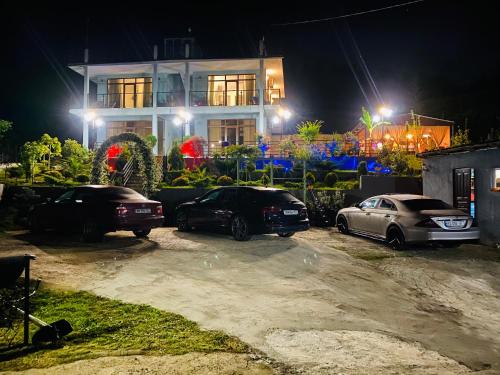 three cars parked in front of a house at night at Family Hotel Sunset in Chakvi