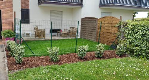 una cerca en un patio con algunas plantas en Cabourg Plage, en Cabourg