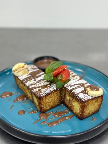a blue plate with two pieces of cake with strawberries on it at فندق سنبات بلاتينيوم in Jazan