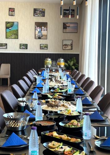 a long table with plates of food and water bottles at فندق سنبات بلاتينيوم in Jazan