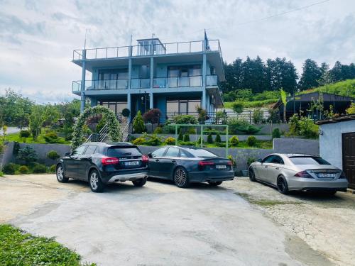 three cars parked in front of a house at Family Hotel Sunset in Chakvi