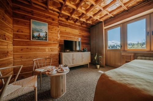 a bedroom with a bed and a tv and a table at Dom Wypoczynkowy U Staszla in Bańska