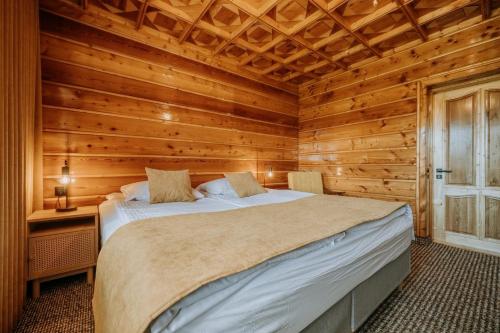 a bedroom with a bed in a wooden cabin at Dom Wypoczynkowy U Staszla in Bańska
