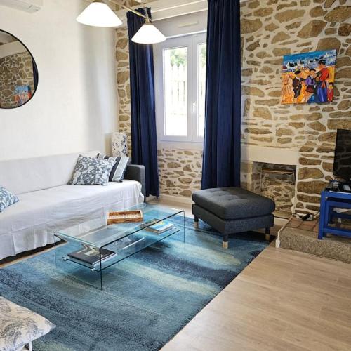 un salon avec un canapé blanc et une table en verre dans l'établissement Jolie maison avec vue mer imprenable proche plage, à Plouguerneau