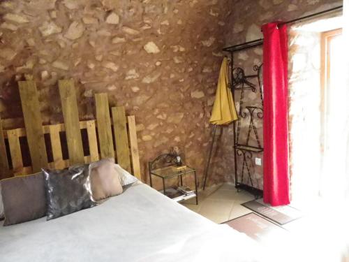 - une chambre avec un lit, un rideau rouge et une fenêtre dans l'établissement le Donjon de la Reine Margot, à Beaumont