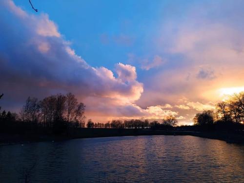 a view of a river with the sunset in the background at Chalupa u Pramenů in Počátky