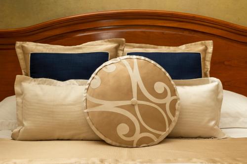 a bed with pillows and a clock on it at Hotel Niko in Zadar