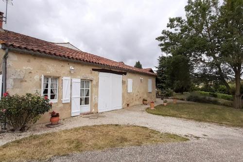 a house with white doors and a yard at Gîte Samaret Gers en Gascogne in Lagardère