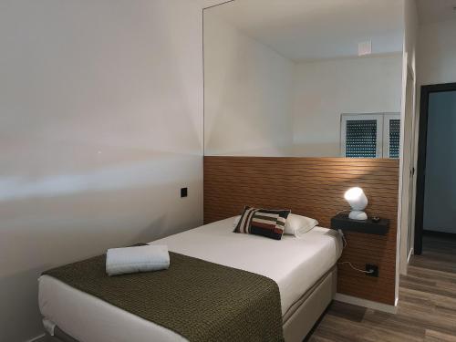 a small bedroom with a bed and a night stand at Casa da Calçada in Maceira