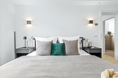 a bedroom with a large white bed with green pillows at La Bastina in Heiligenhafen