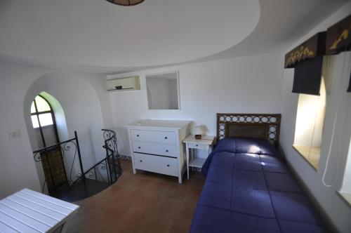 a bedroom with a bed and a dresser and a desk at Villa Eva in Anacapri