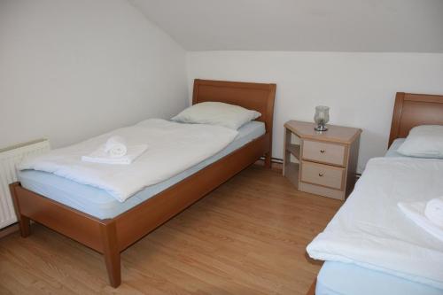 een slaapkamer met 2 bedden met een hoed erop bij Apartma narava in Begunje pri Cerknici