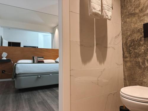 a bathroom with a toilet and a bed in a room at Casa da Calçada in Maceira