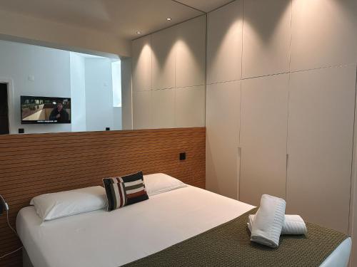 a bedroom with a white bed and a mirror at Casa da Calçada in Maceira