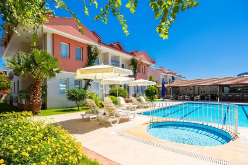 a pool at a hotel with chairs and umbrellas at Safak Oasis Hotel in Dalyan