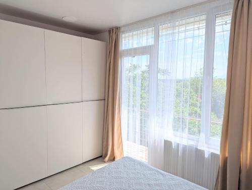 a bedroom with a large window and a bed at Cosy At Home in K'obulet'i