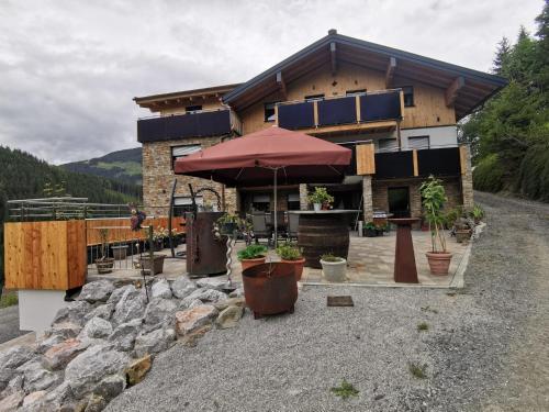 a house with an umbrella in front of it at Landhaus Oberzinnegg in Saalbach Hinterglemm