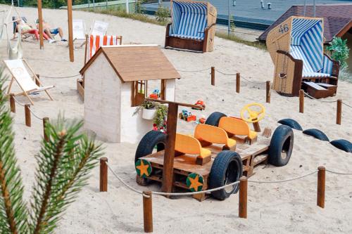 a toy train in the sand on a beach at FOREST Family Resort Ustka in Ustka