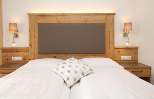 a bedroom with a white bed with two lamps at Alpenperle in Ramsau am Dachstein