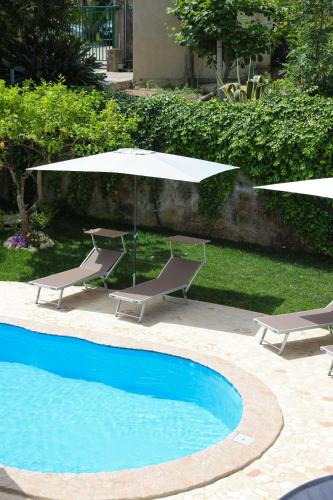 two chairs and an umbrella next to a swimming pool at B&B Casita GioJa in Gasponi