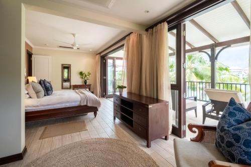 1 dormitorio con 1 cama y balcón en Maison L'Amirale by Simply-Seychelles en Eden Island