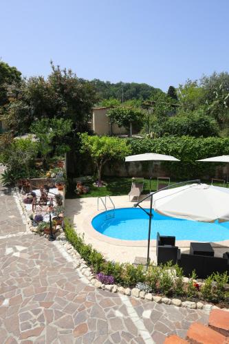 a swimming pool with an umbrella and chairs and a table and an umbrella at B&B Casita GioJa in Gasponi