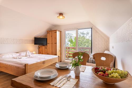 una camera da letto con un letto e un tavolo con una ciotola di frutta di Vineyard Cottage Rataj 2 a Novo Mesto