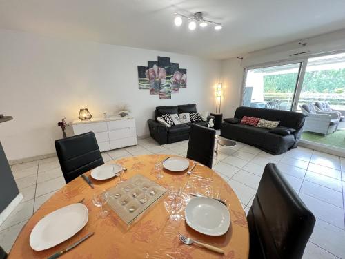 une salle à manger avec une table et des chaises et un salon dans l'établissement Sol-y-Days Indigo, spacieux appartement a deux pas des plages, à La Grande Motte