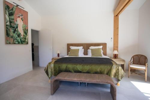a bedroom with a large bed and a chair at Hotel Le Verger Maelvi in Grimaud