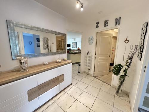 une cuisine avec un comptoir avec un miroir et un couloir dans l'établissement Sol-y-Days Indigo, spacieux appartement a deux pas des plages, à La Grande Motte