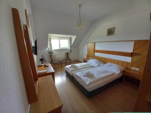 sypialnia z dużym łóżkiem i biurkiem w obiekcie Hotel Familia w Zamárdi