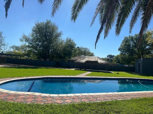 an empty pool in a yard with a palm tree at Starpoint Guest house in Vereeniging