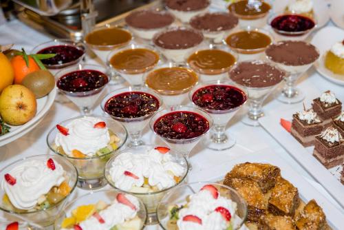 a table topped with glasses of desserts and desserts at PARK Hotel & SPA Jablanica in Jablanica