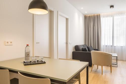 a living room with a table and chairs and a couch at Mon Suites Jardín de Ayora in Valencia