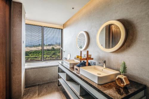 a bathroom with a sink and a mirror at The Botanica Sanctuary in Puncak