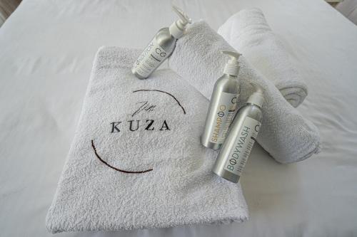 two complimentary towels on a bed with two injection bottles at Kuza The Palm Villas at Vipingo in Kilifi