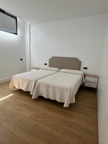 a bedroom with a large bed with white sheets at Apartamentos Arcos de Montemar in Torremolinos